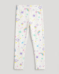 
Full-length white girls' slim-fit leggings with all-over pastel magic-themed print including rainbows, stars, hearts, crowns, cupcakes and paint splashes, laid flat on a white background.