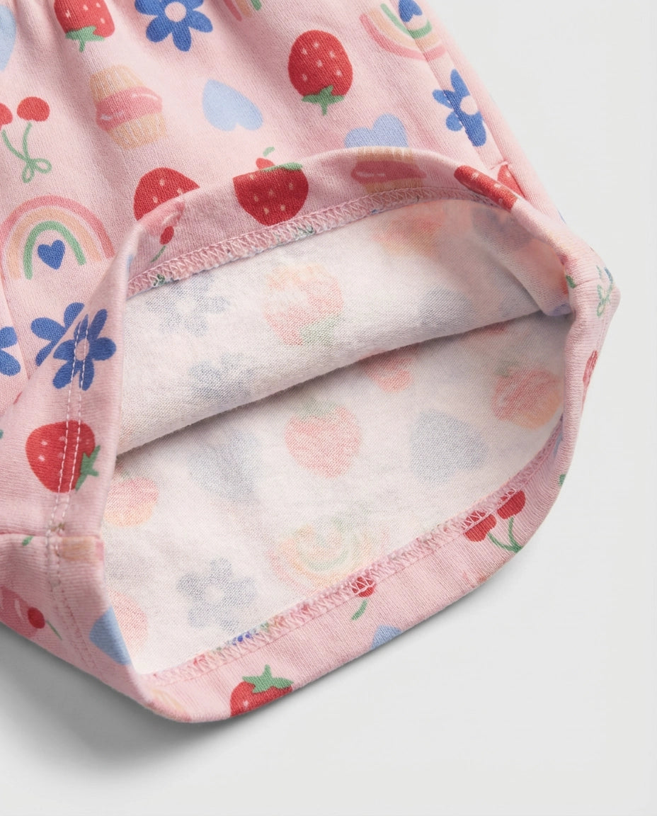 Front flat-lay view of girl's blush pink short pant with all-over multicolour strawberry, cherry, cupcake, rainbow, daisy and heart print and ruched paperbag elasticated waistband