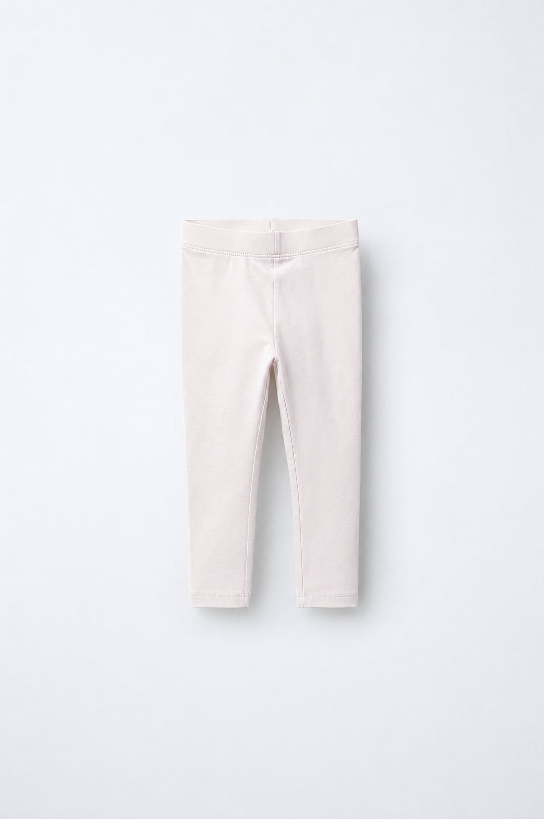 Girls’ pale blush pink leggings with elastic waistband, slim tapered legs and neatly stitched ankle hems.