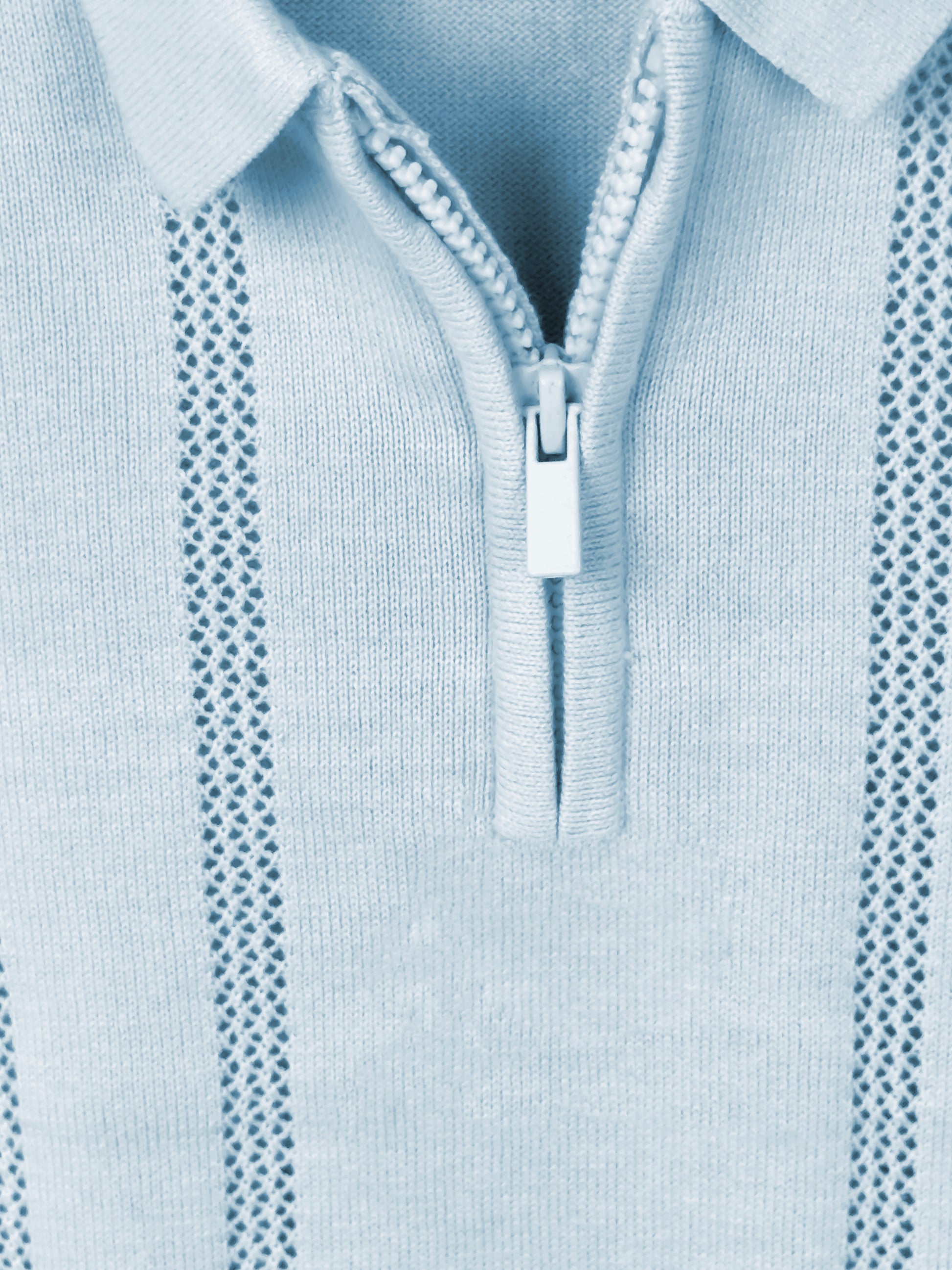 Close-up of a light blue sweater with a zipper detail
