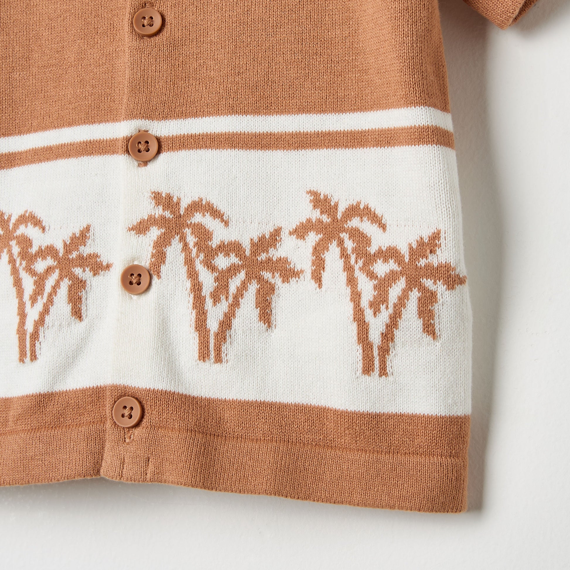 Knitted cardigan with palm tree pattern on a white background