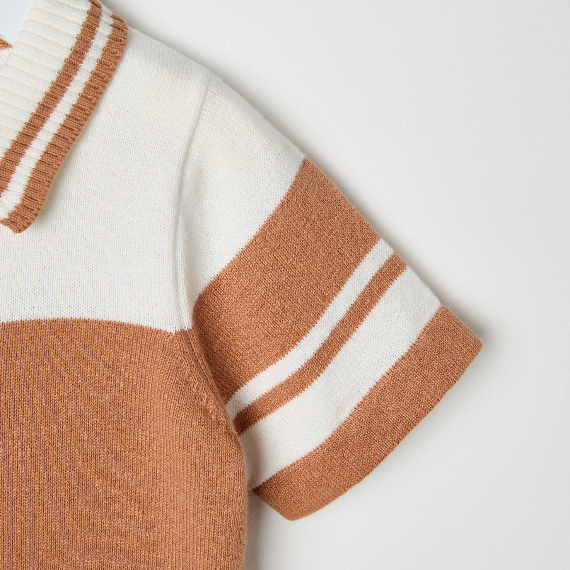 Close-up of a sweater with brown and white stripes on a light gray background