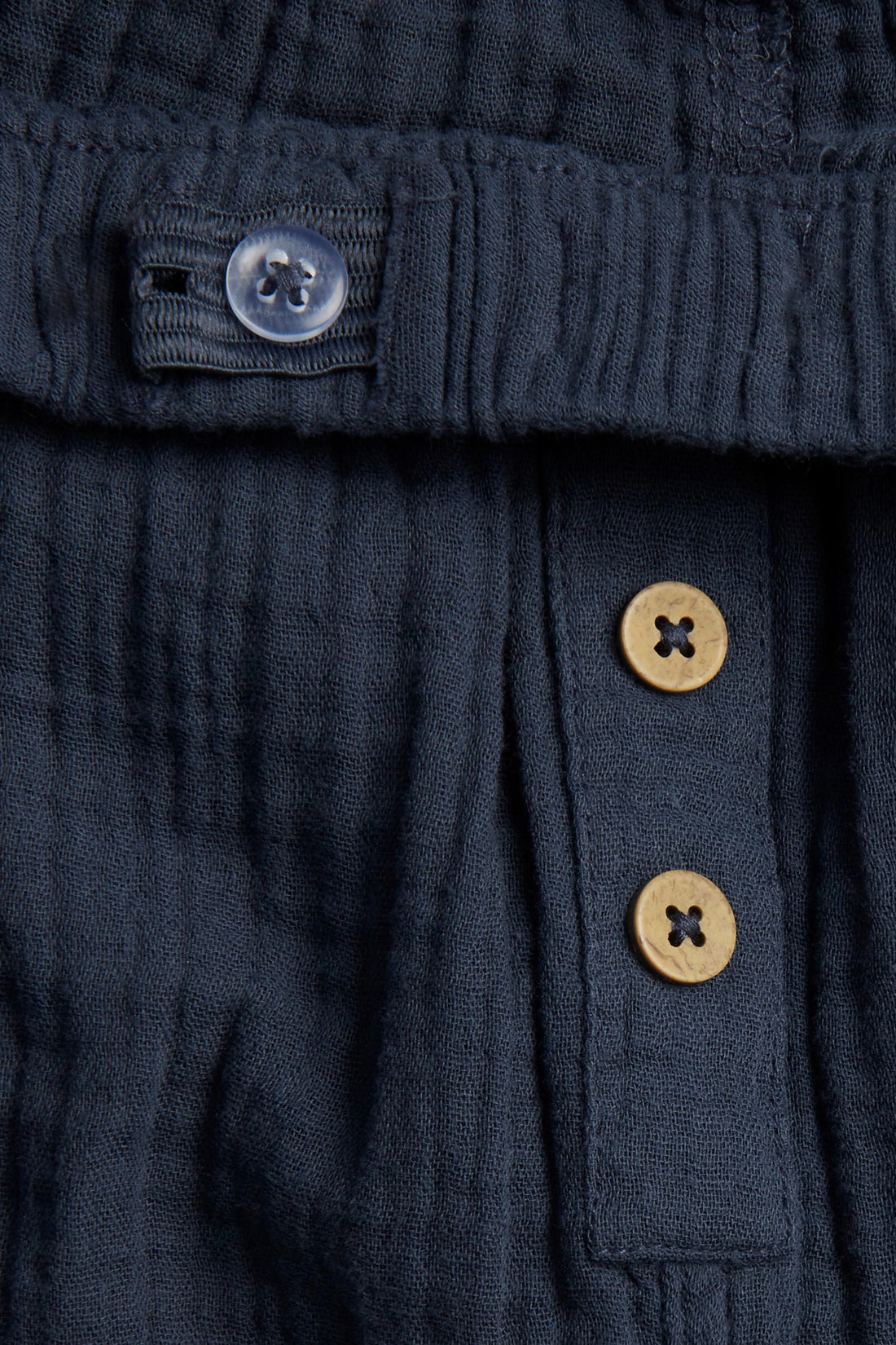 Navy blue kids' muslin trousers with drawstring waist, button placket and side pockets, flat lay — PTex Fashion