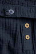 Close-up of internal waist adjuster button and coconut-look button placket on navy blue kids' muslin trousers — PTex Fashion