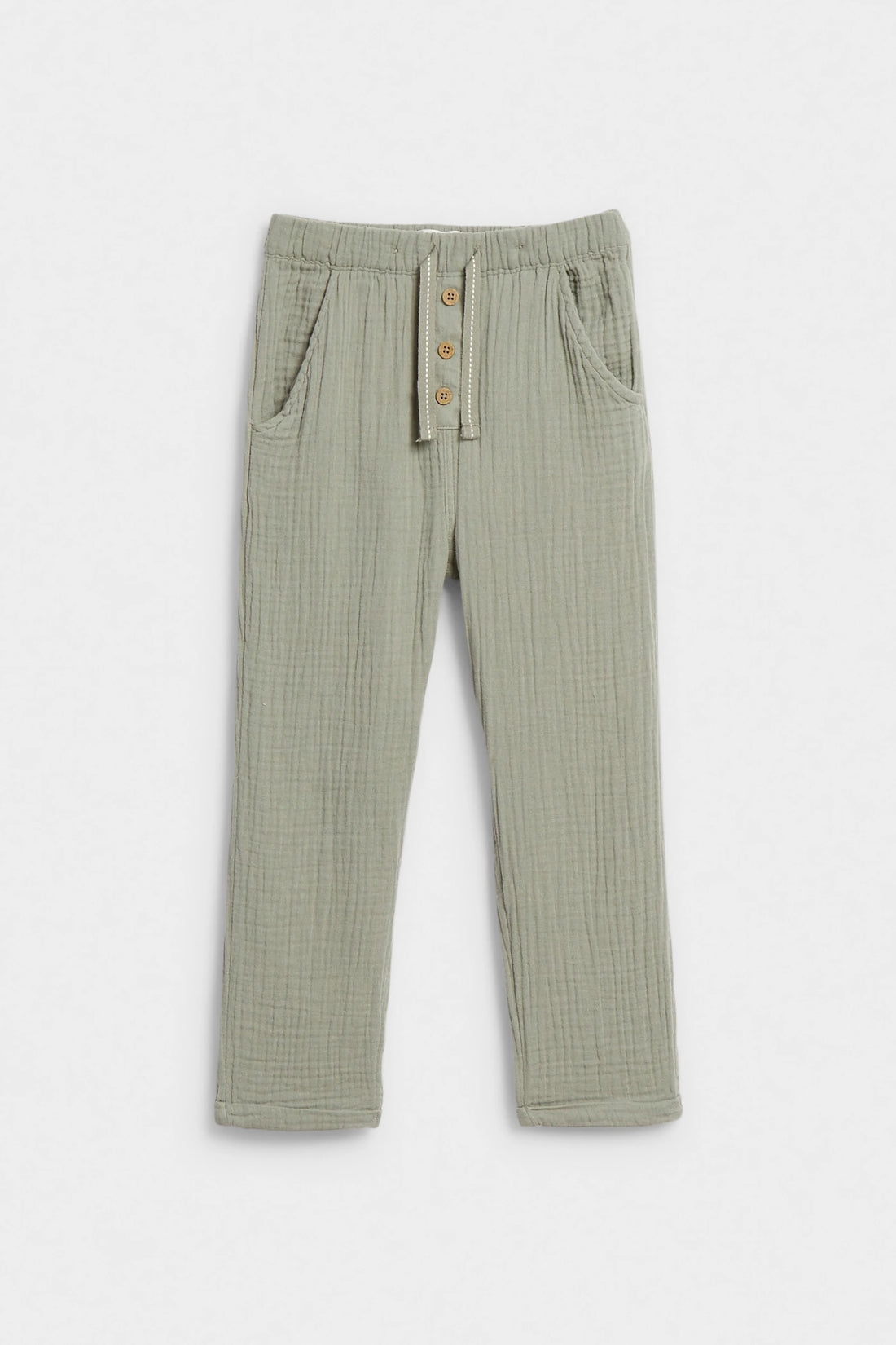 Sage green kids' muslin trousers with elasticated waist, button placket and side pockets, flat lay — PTex Fashion