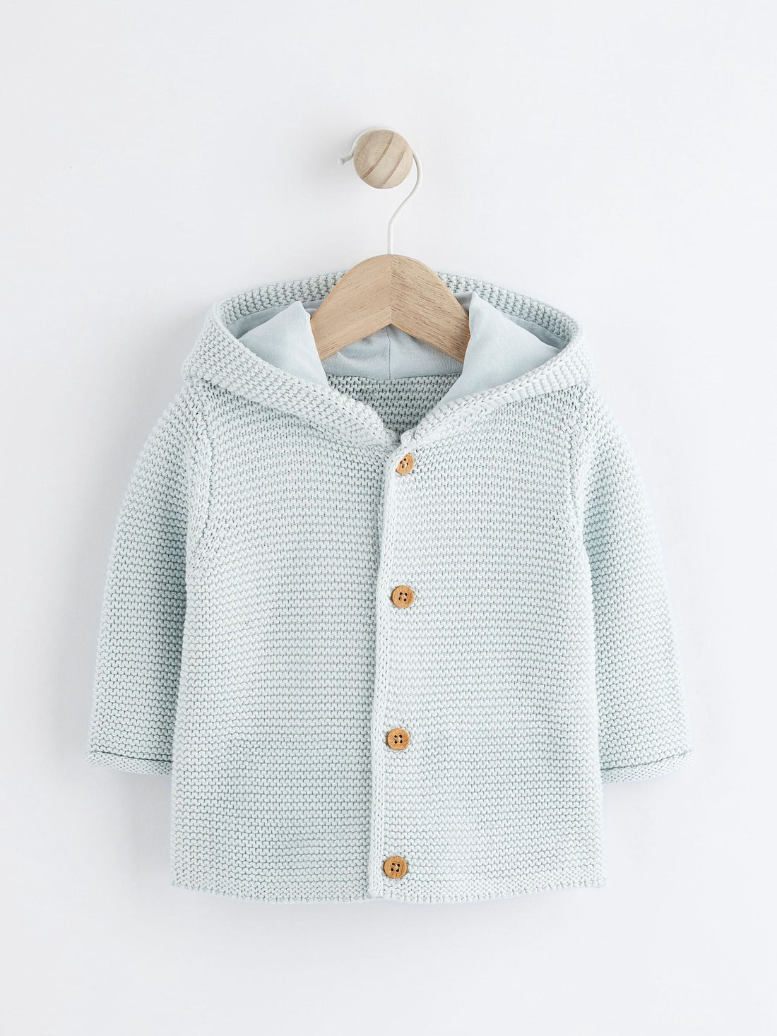 Knitted baby cardigan with buttons on a white background