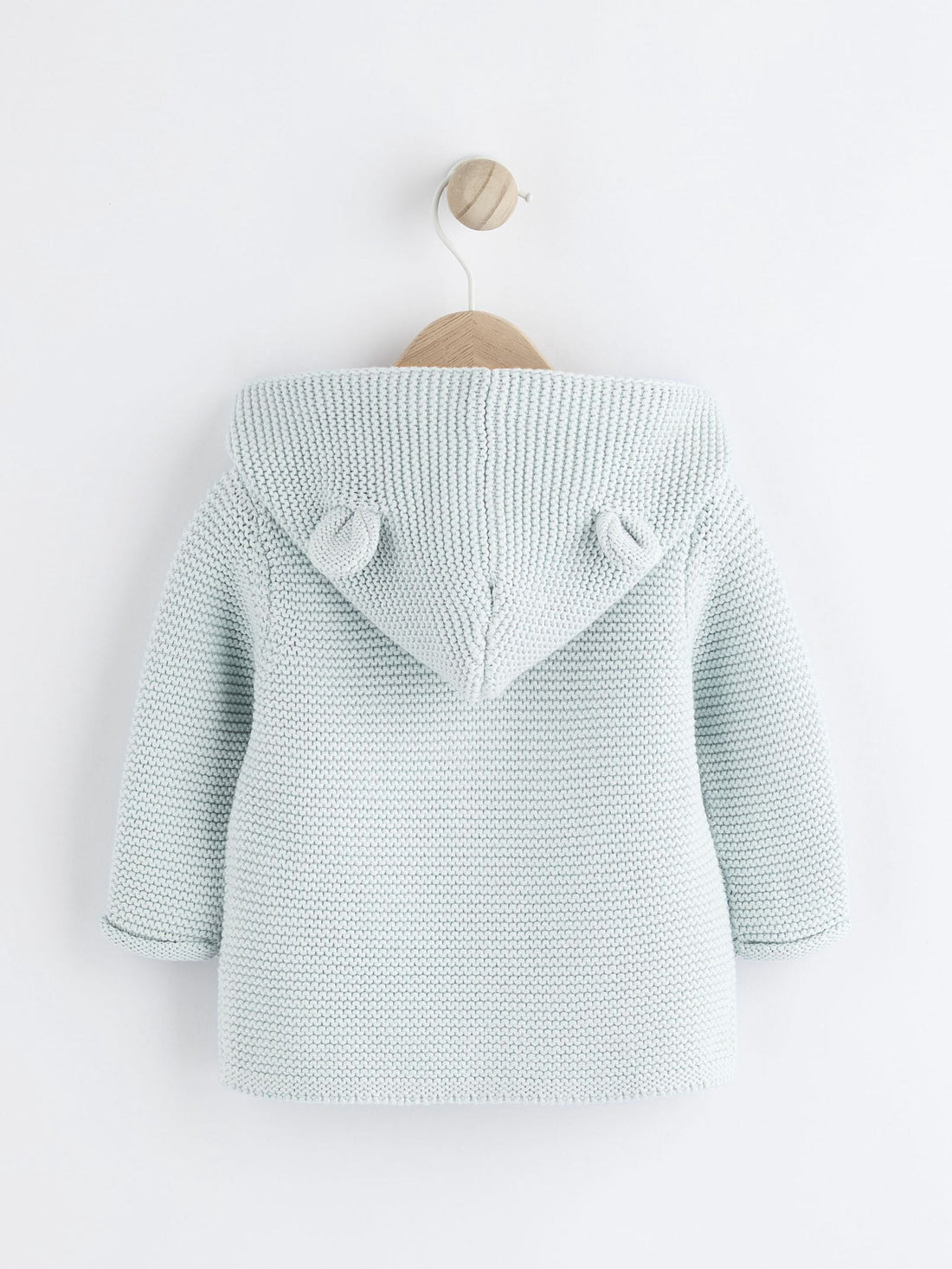 Knitted baby cardigan with buttons on a white background