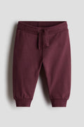 Maroon sweatpants on a light gray background