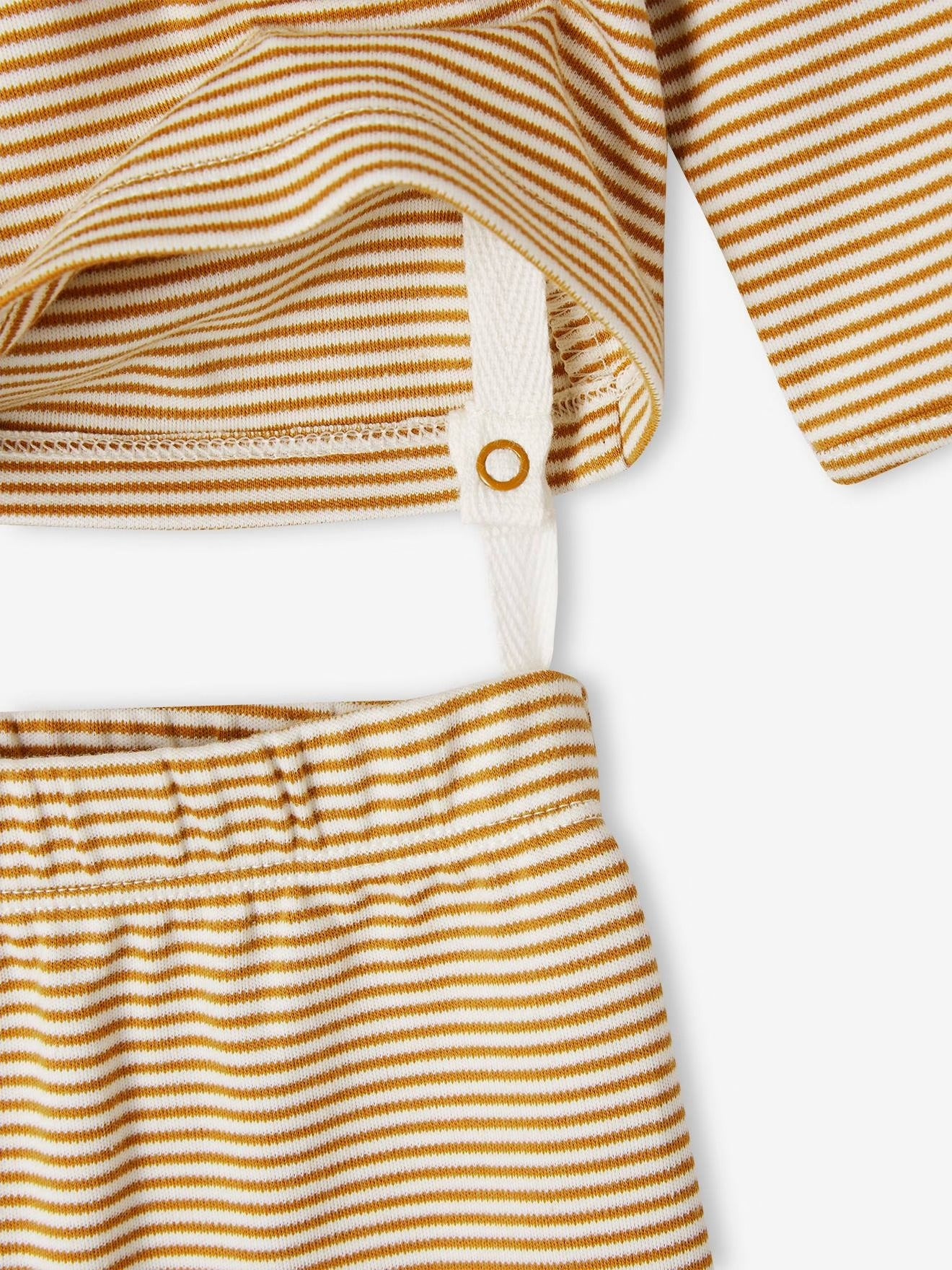 Close-up of a yellow and white striped fabric with a button on a white background