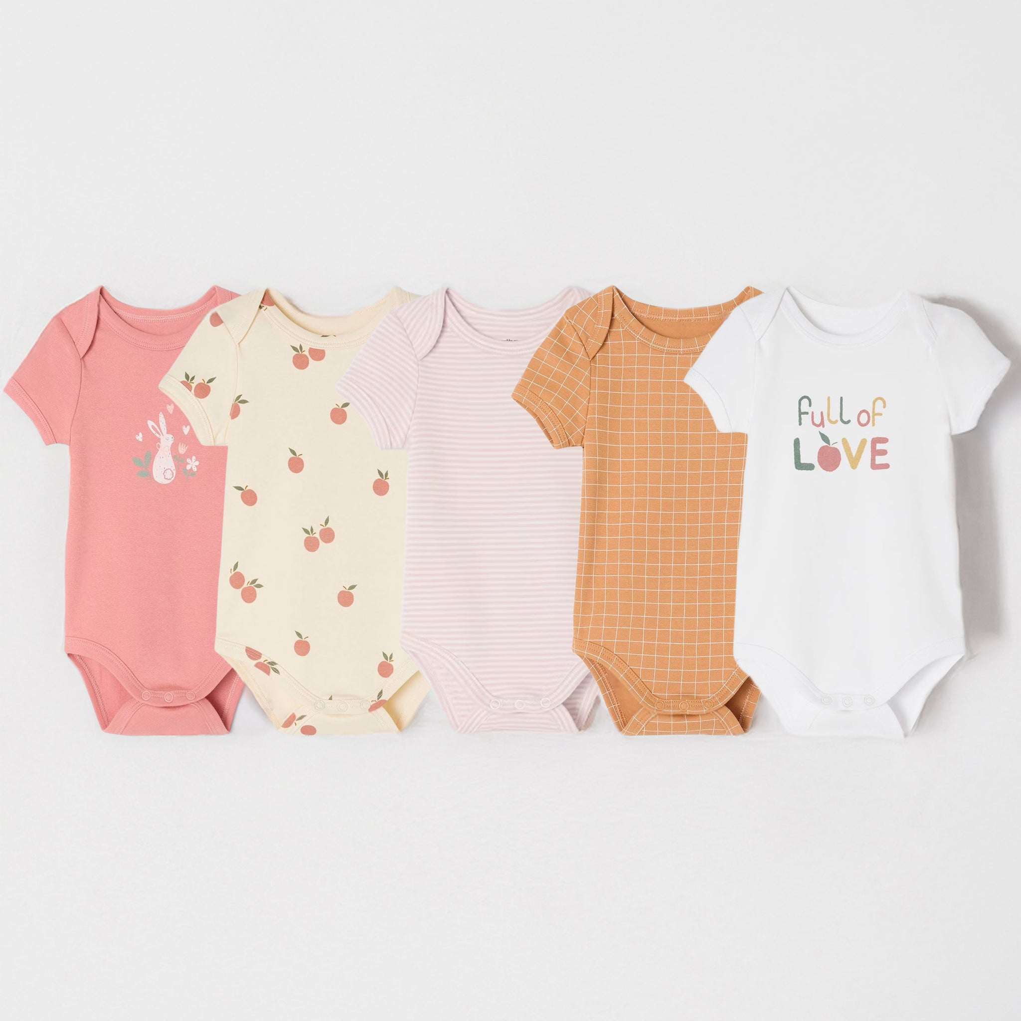 Five baby bodysuits in various colors and patterns on a white background