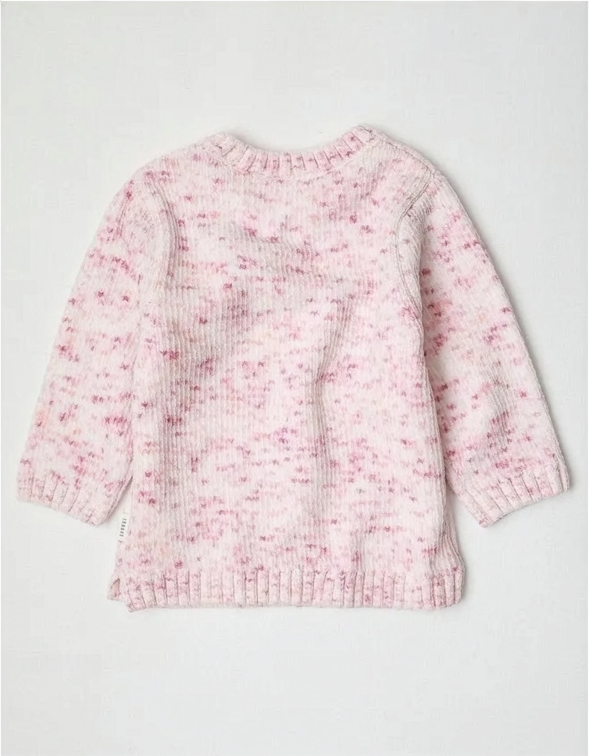 Pink and white knitted jumper on a light gray background