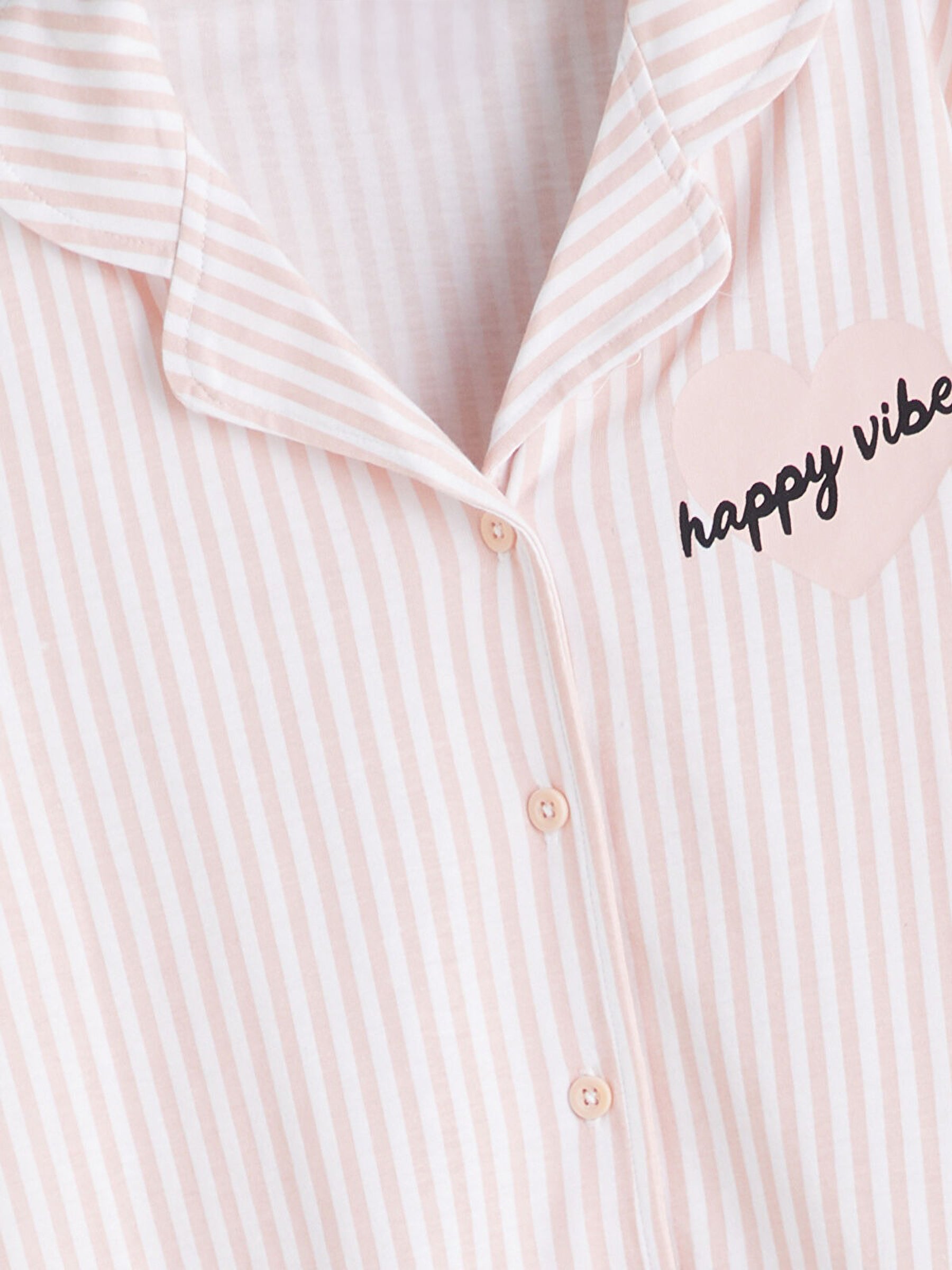 Pink and white striped shirt with 'happy vibes' text on a white background