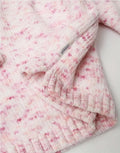 Pink and white textured baby jumper on a light background