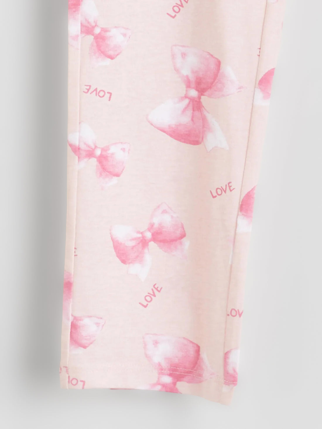 Pink pajama pants with a subtle pattern on a light gray background
