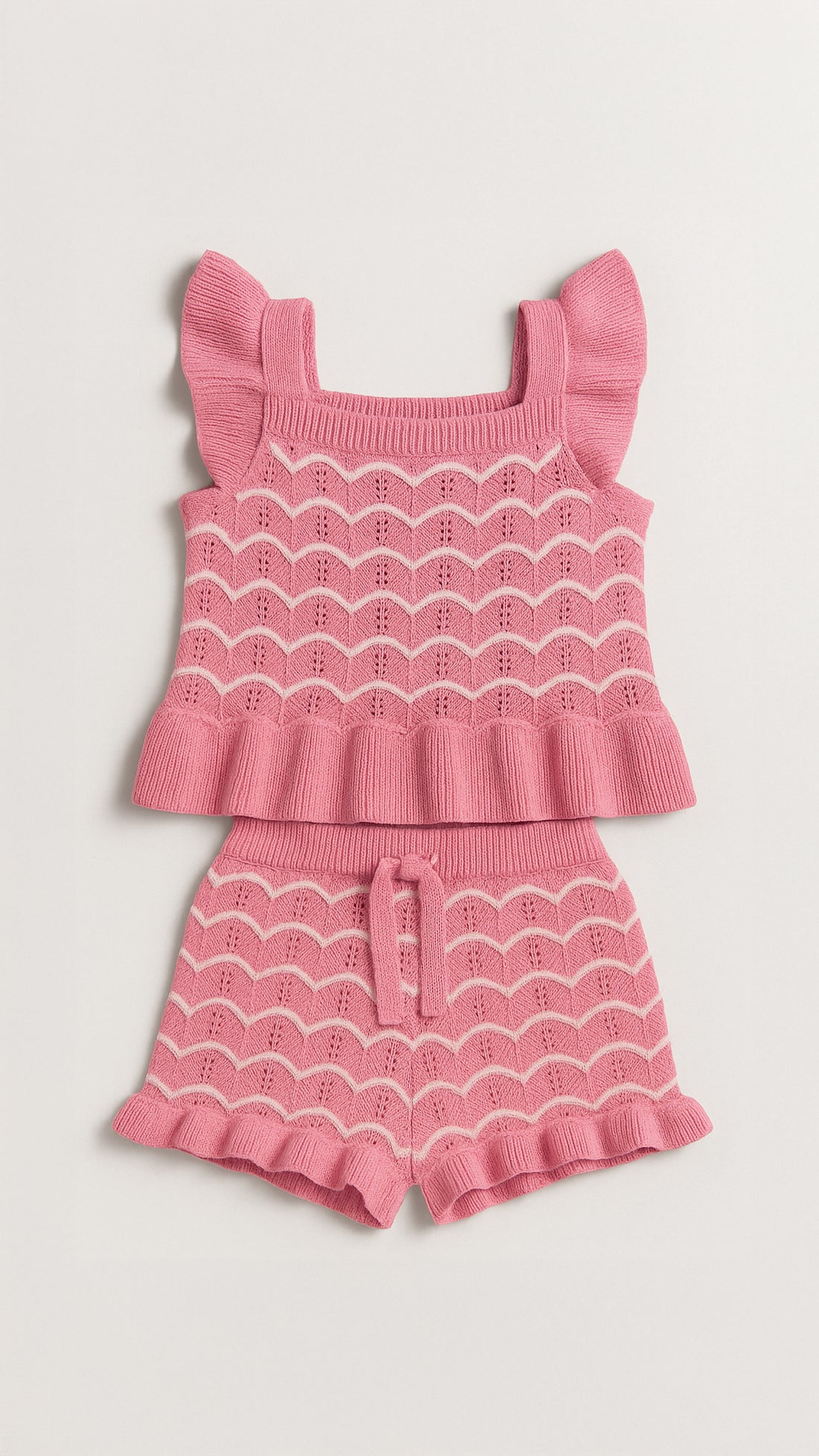 Young girl wearing a pink and white striped outfit with ruffled sleeves against a beige background