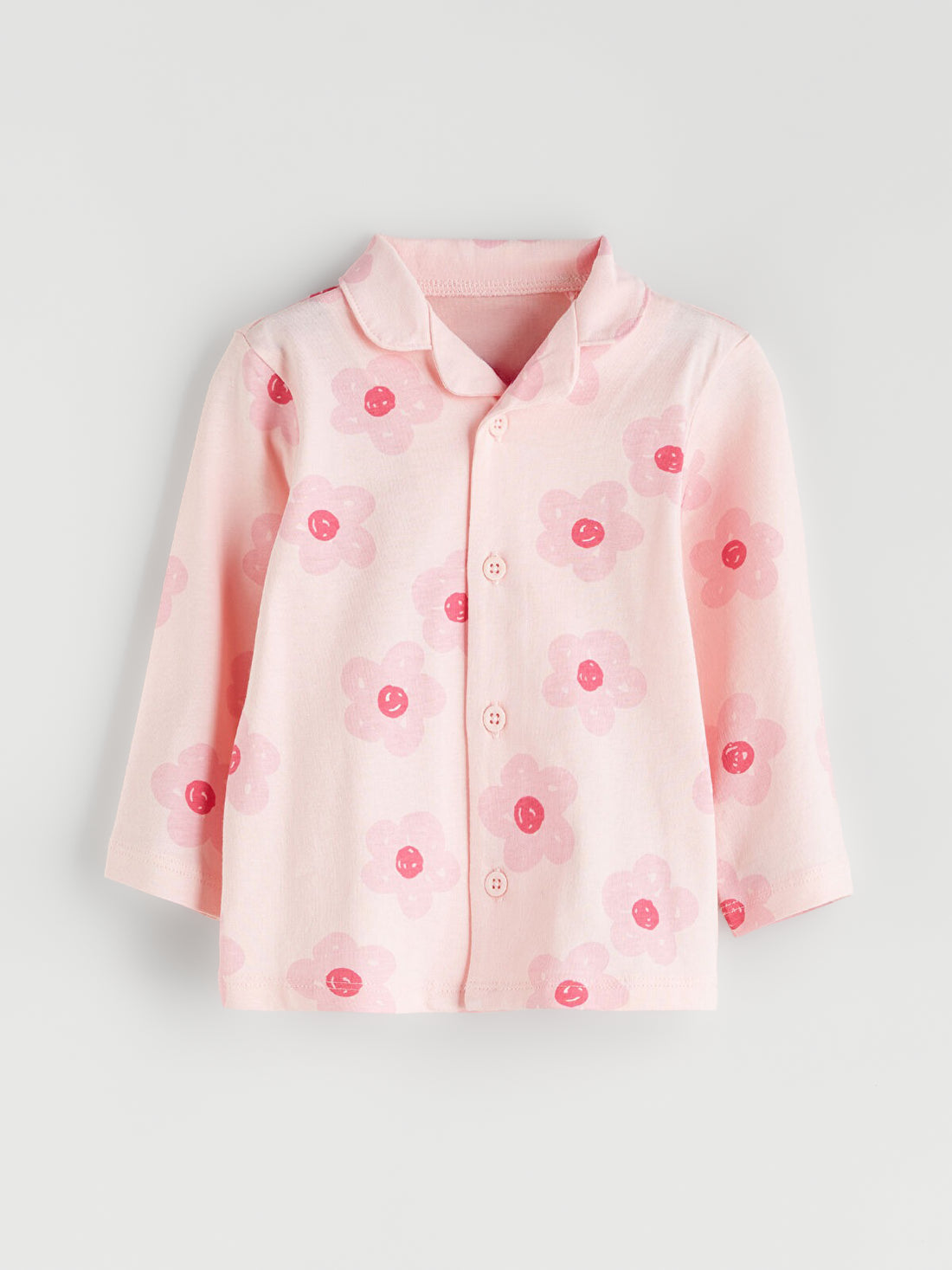 Pink shirt with red floral patterns on a light gray background