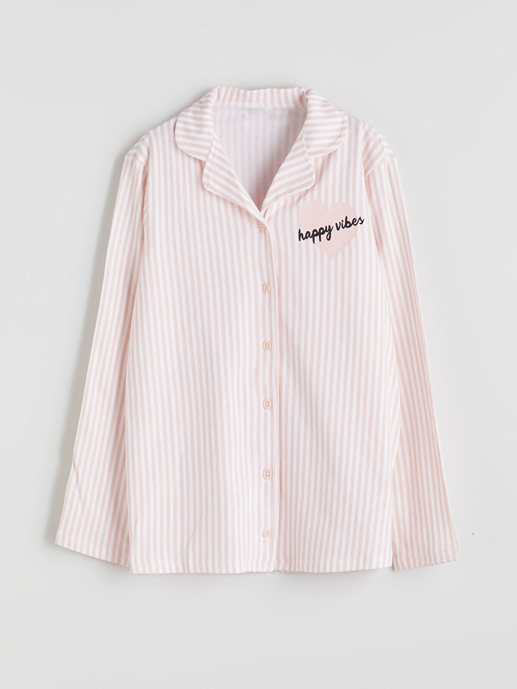 Pink striped shirt with 'happy vibes' text on a light gray background