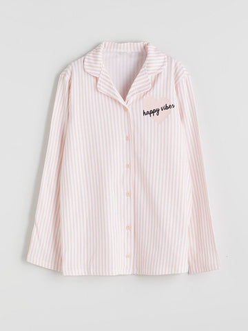 Pink striped shirt with 'happy vibes' text on a light gray background