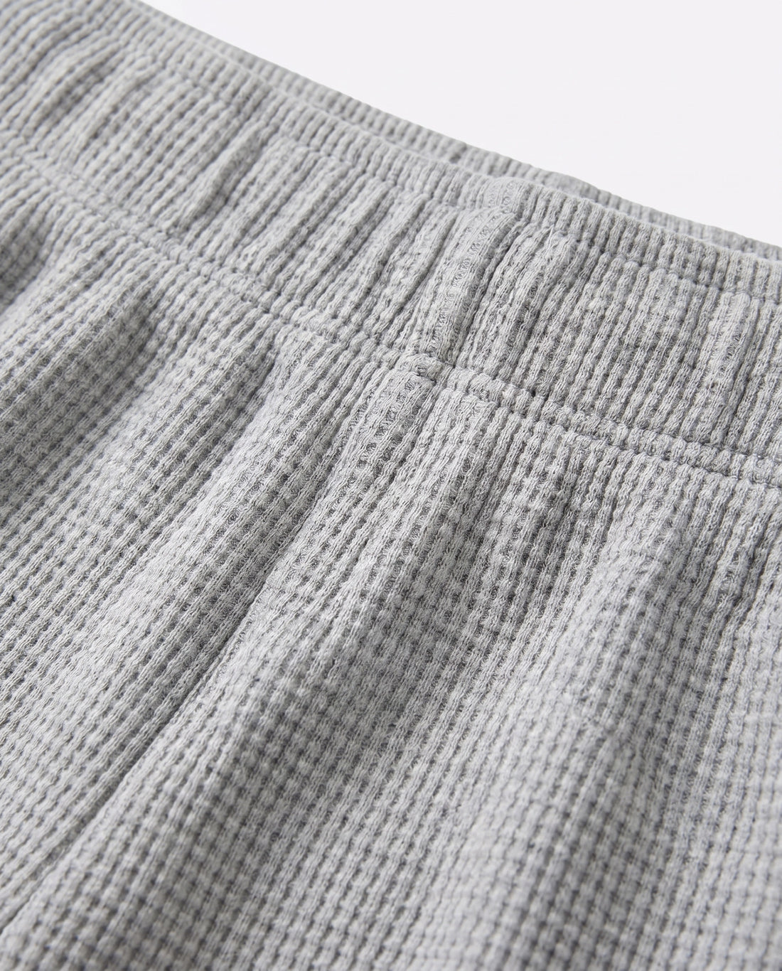 Full front flat-lay view of toddler waffle cotton short pants in light grey with elasticated waistband and relaxed short-length silhouette on white background.