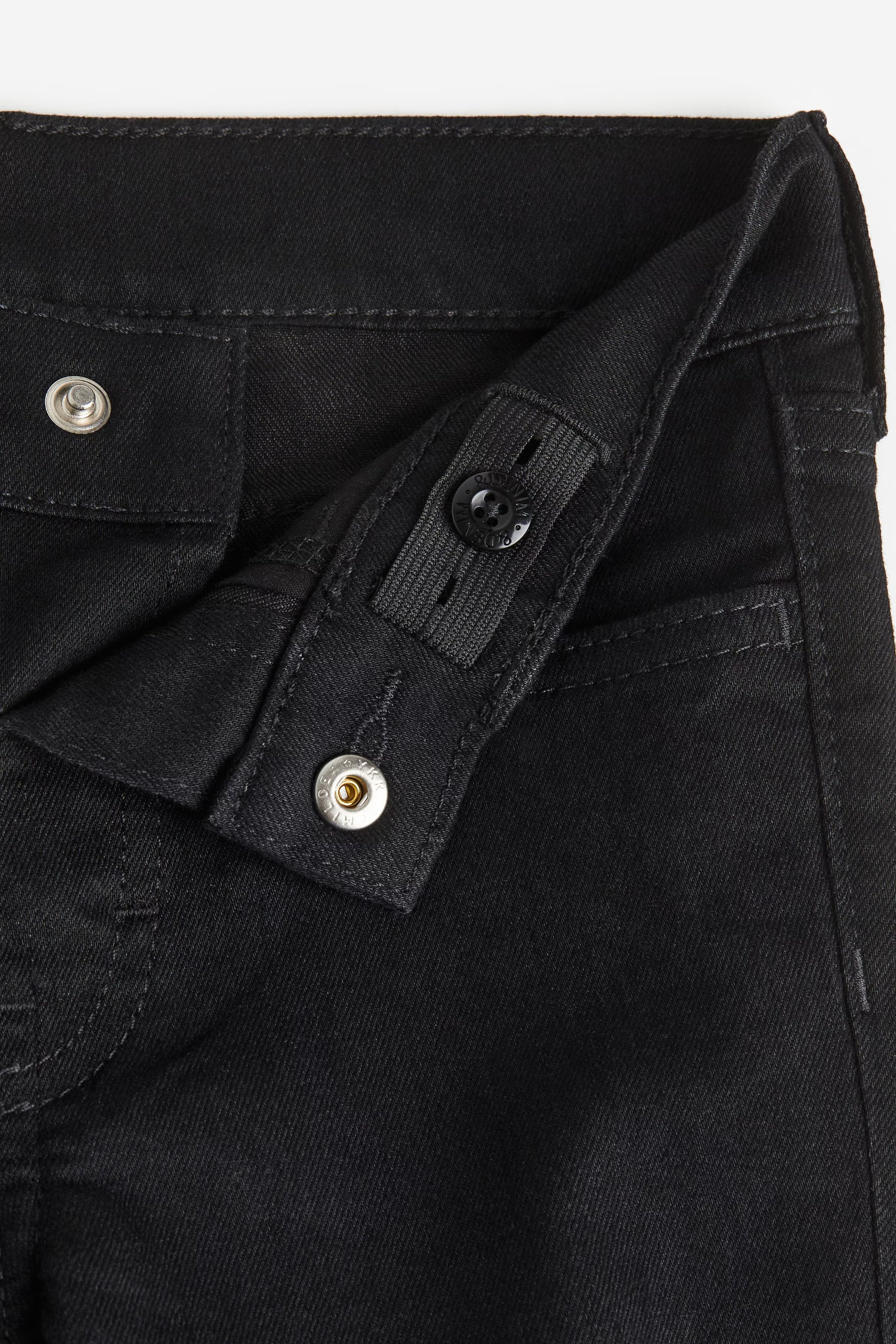 Close-up of a black jacket with buttons on a white background
