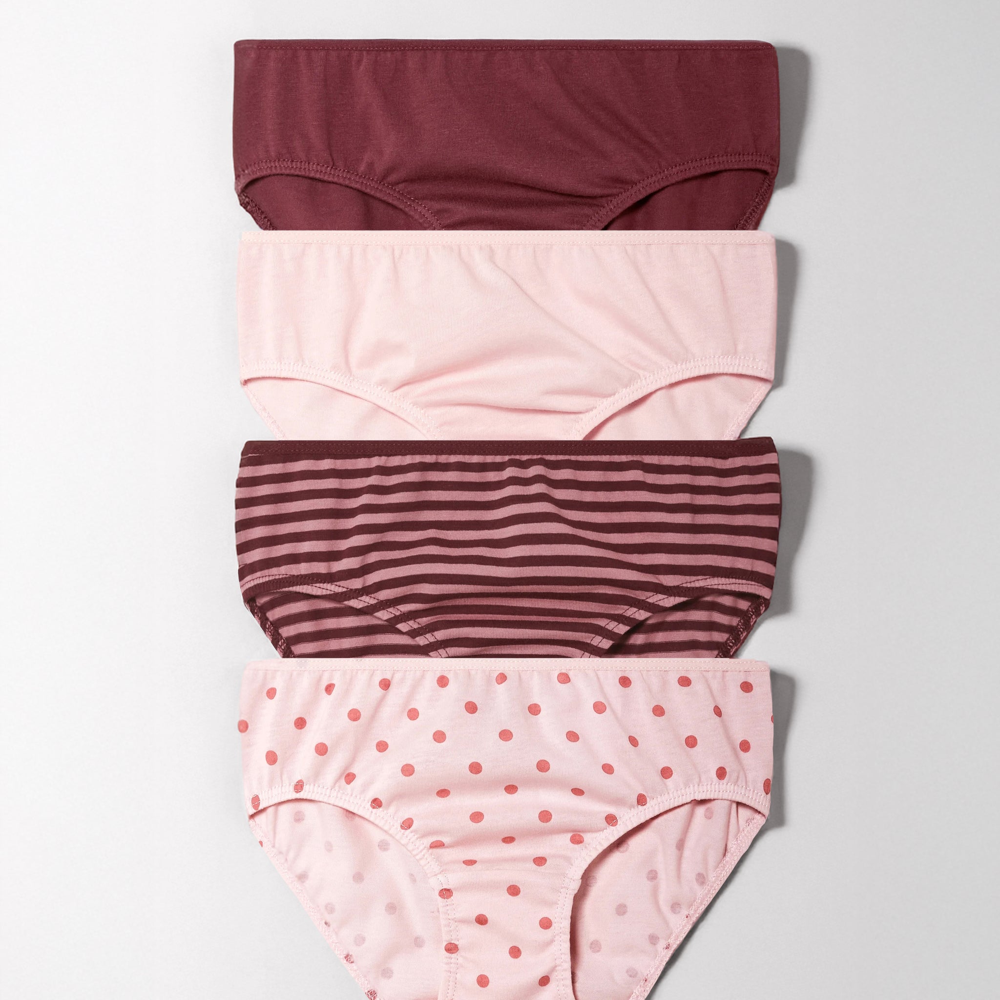 Set of four girl's underwear with different patterns on a light gray background
