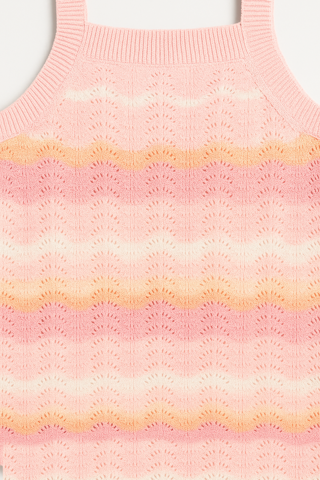 Close-up of a pink and orange striped knitted sleeveless sweater.