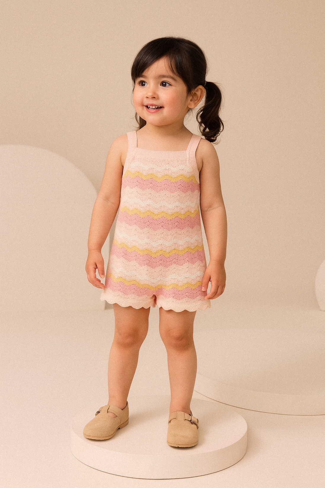 Young girl wearing a pink and yellow striped dress on a beige background