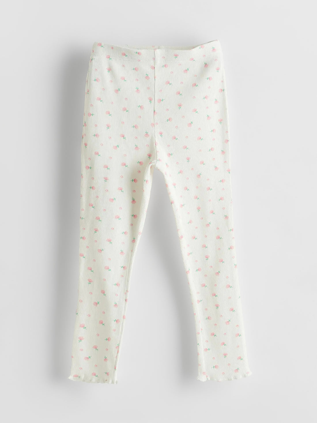 White leggings with small pink patterns on a light gray background