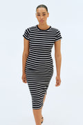 Woman wearing a black and white striped midi dress on a white background