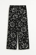 Black pants with white floral pattern on a white background