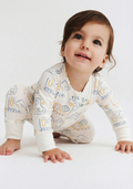 a toddler baby wearing a white all over print baby romper with front zipper