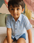 Close-up of a toddler boy in a PTex Fashion carrot print short-sleeve button-up shirt
