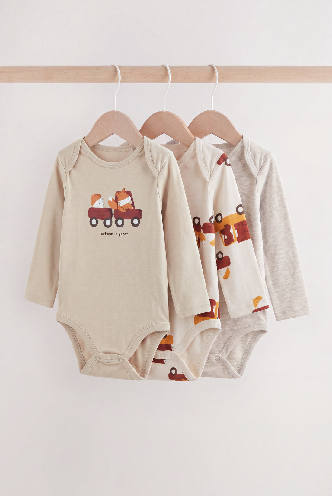 PTex Fashion baby 3-pack long-sleeve cotton bodysuits in neutral oatmeal, cream and grey marl on wooden hangers