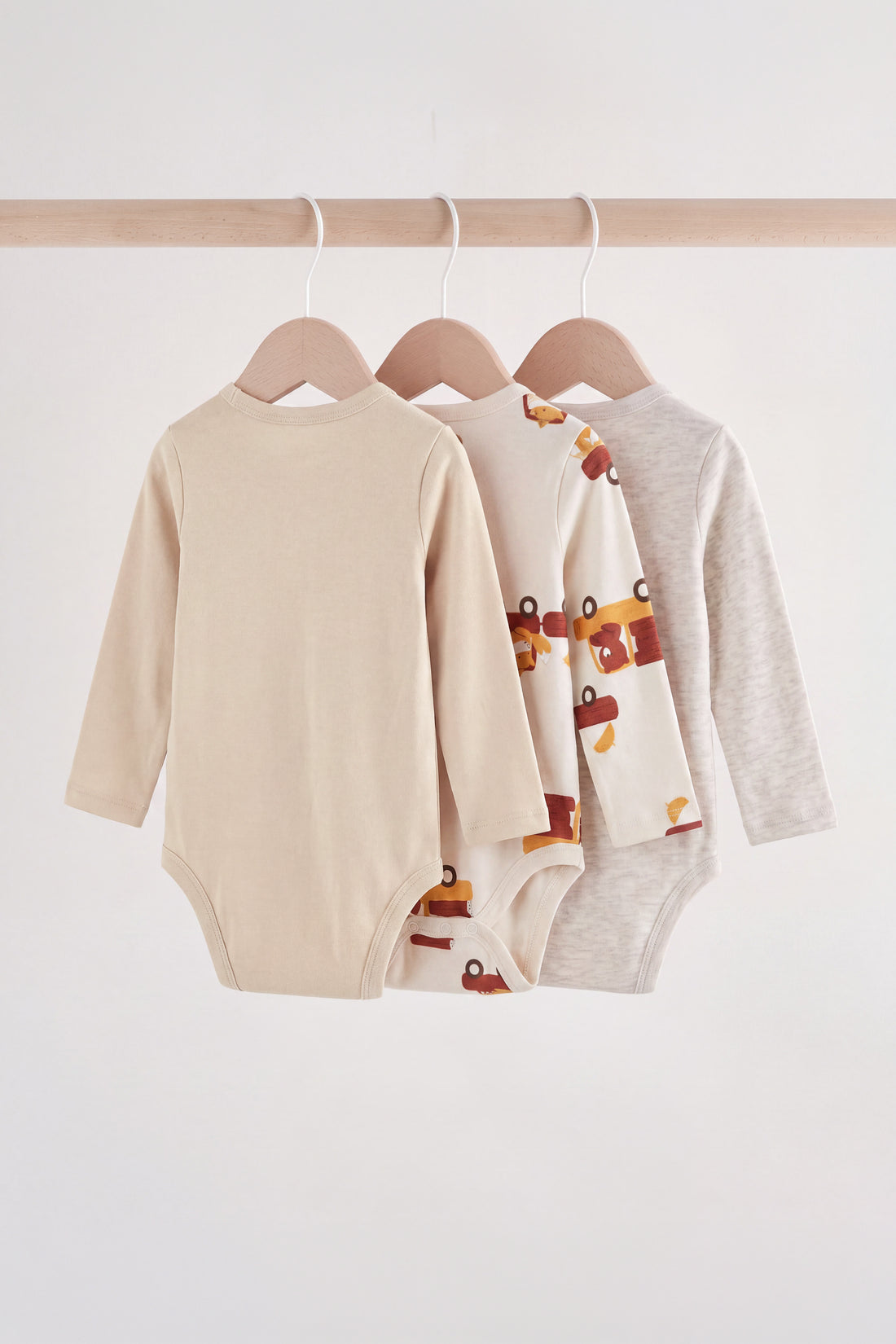 PTex Fashion baby 3-pack long-sleeve cotton bodysuits in neutral oatmeal, cream and grey marl on wooden hangers