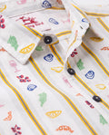 Close-up of white cotton boys shirt with colorful food prints and yellow blue stripes
