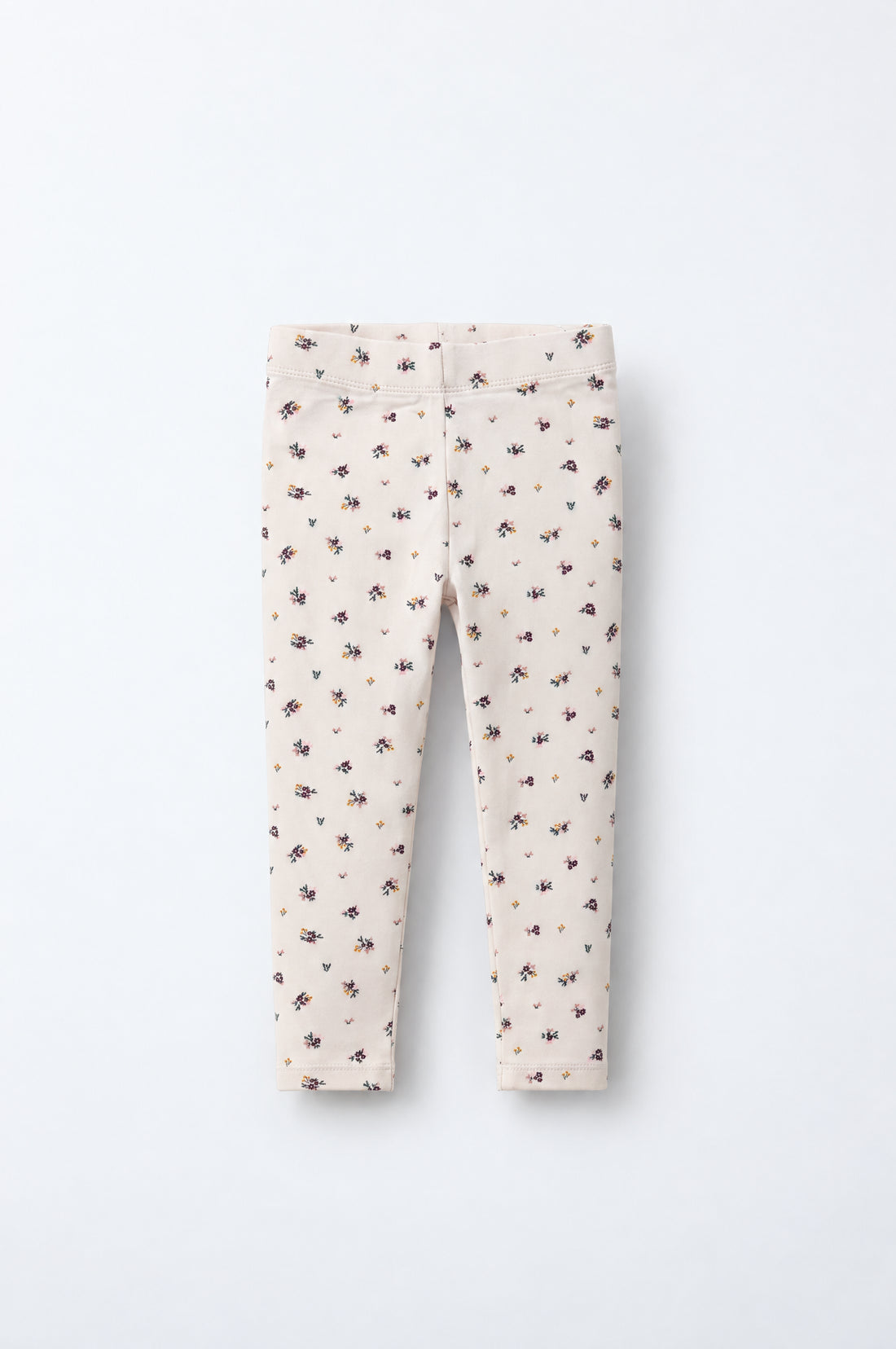 Baby girl cream leggings with tiny burgundy, pink, mustard and green floral print, elasticated waistband and neatly stitched hems.