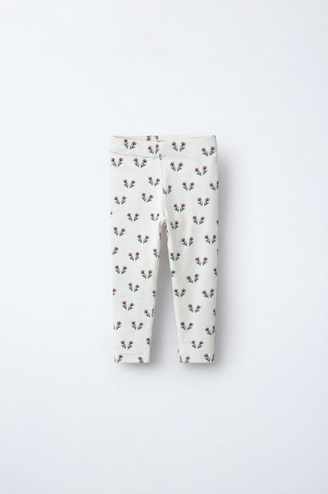 Baby girl off-white leggings with small pink and green floral print, elasticated waistband and neatly finished hems.