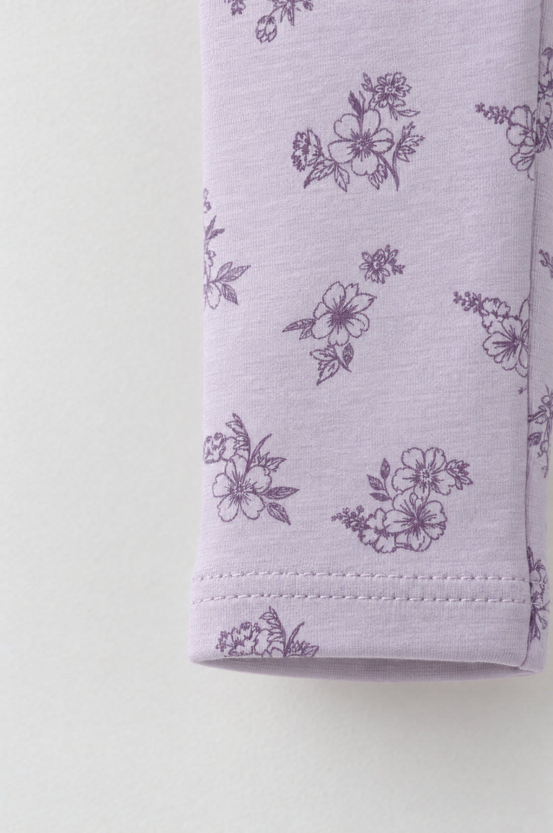 Baby girl lilac leggings with dark purple floral print, elastic waistband and double-stitched leg hems.