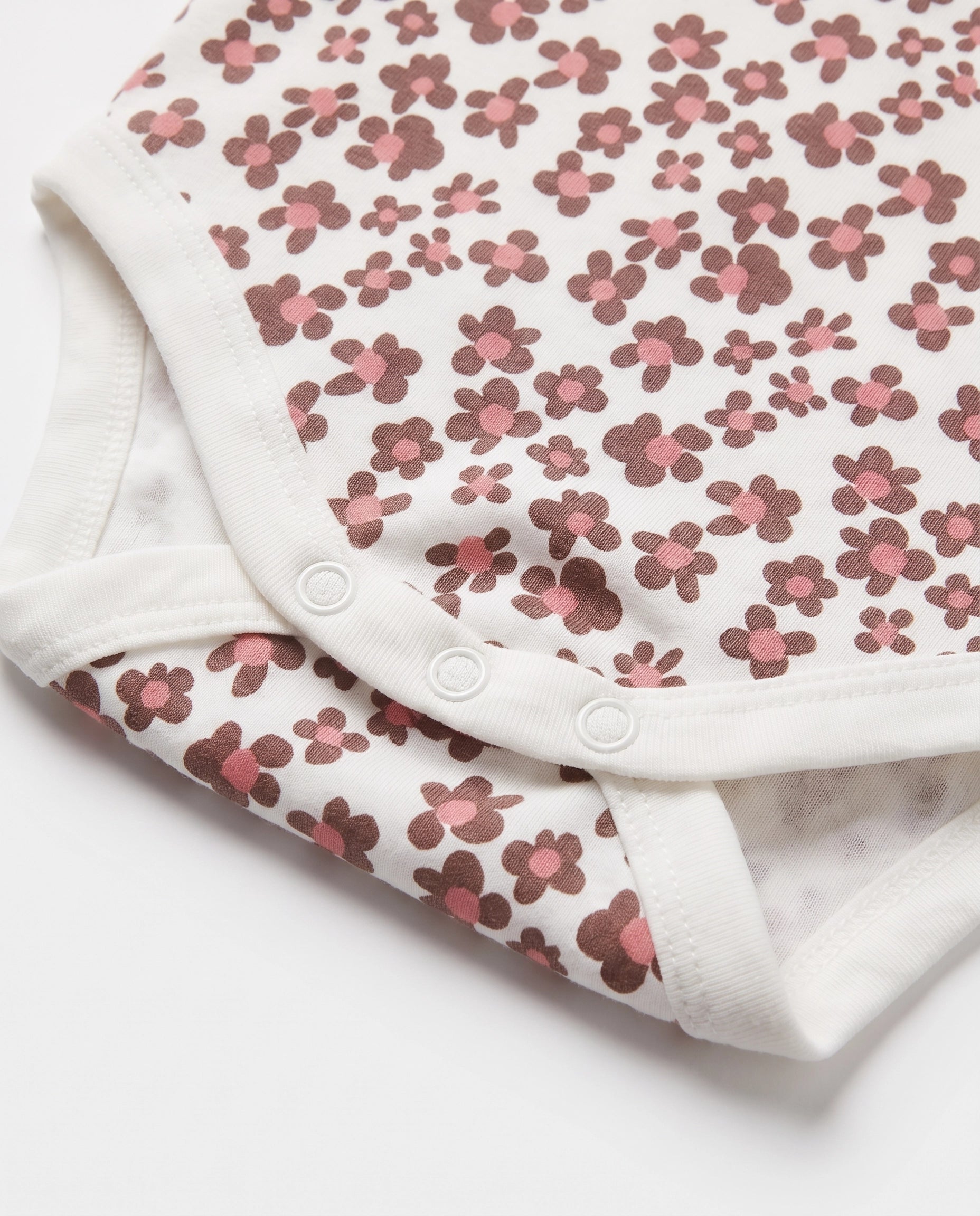 Close up of three popper crotch fastening on baby girls floral print cotton bodysuit – PTex Fashion