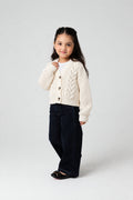 Girl wearing PTex Fashion ivory chenille cable knit boxy cardigan over a white tee with dark wide-leg jeans