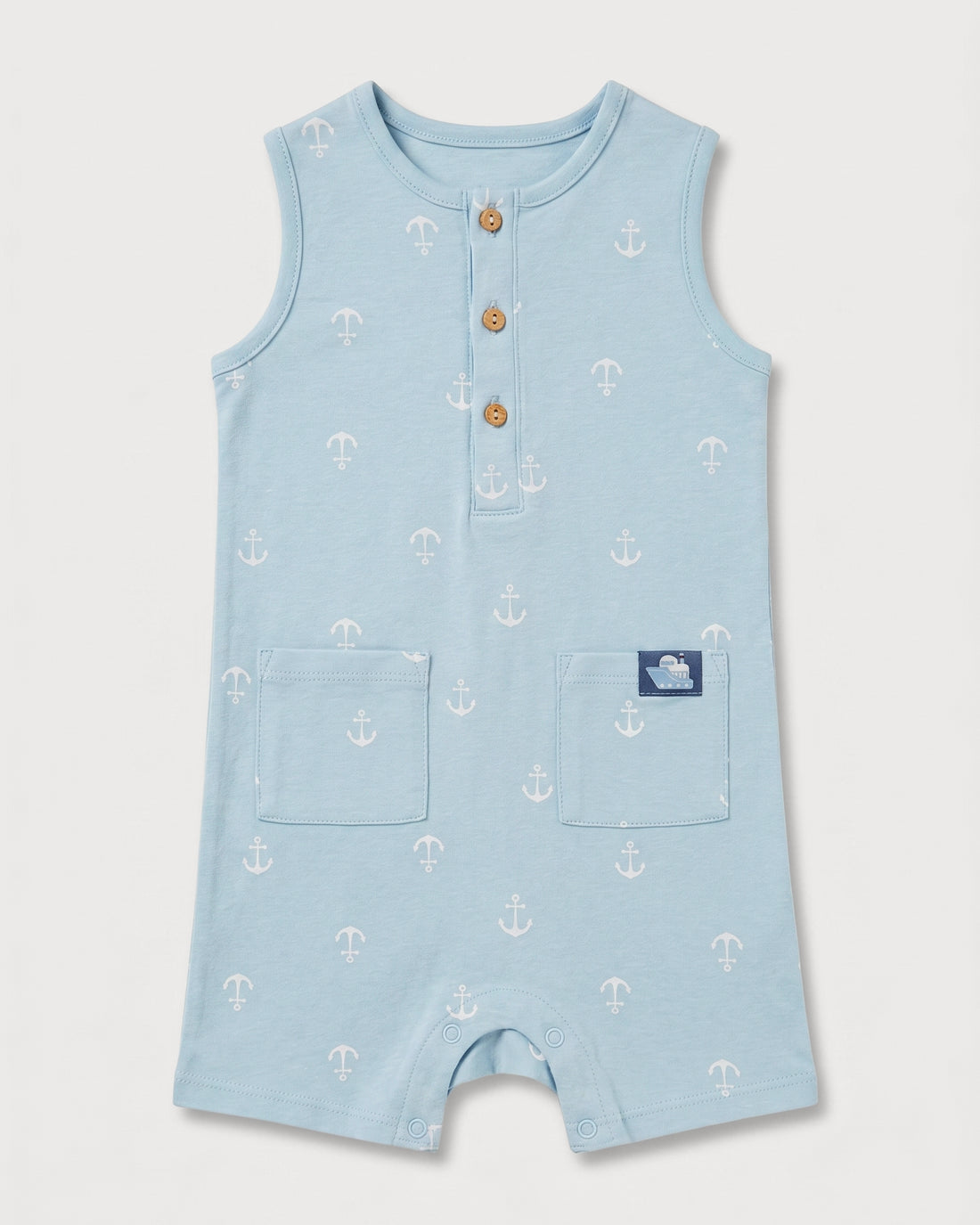 Full front view of baby boys' sleeveless blue anchor print romper with patch pockets and boat badge detail