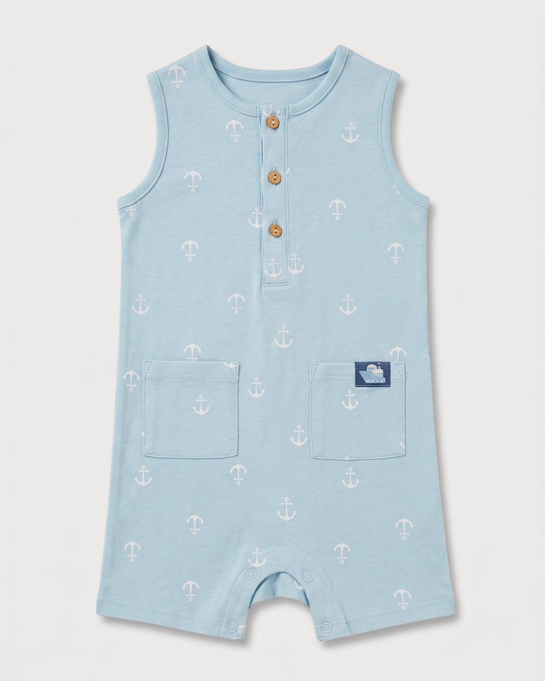 Full front view of baby boys' sleeveless blue anchor print romper with patch pockets and boat badge detail