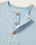 Close-up of sky blue baby romper with wooden henley buttons and all-over white anchor print