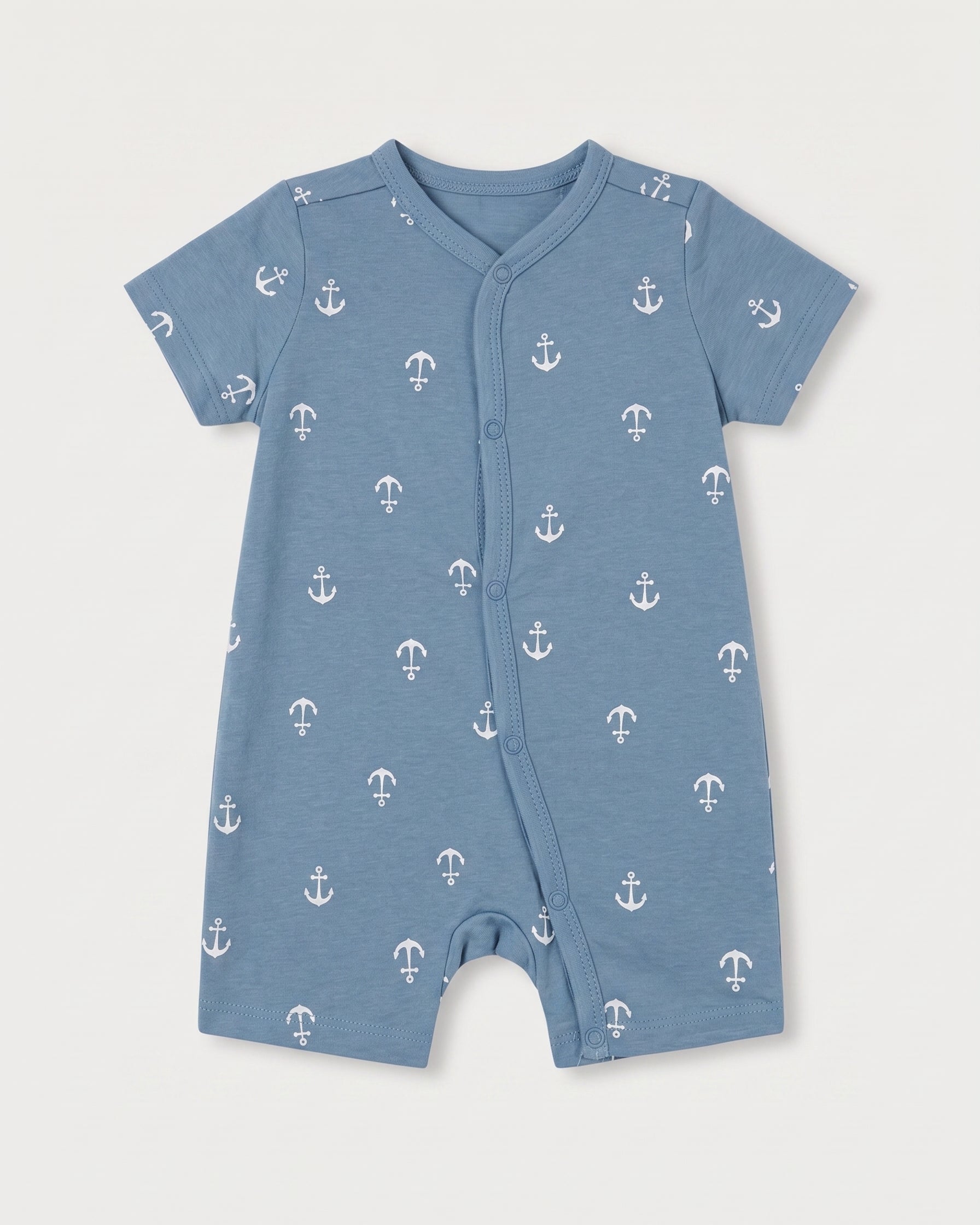 Steel blue baby jumpsuit with white nautical anchor print, short sleeves, and diagonal snap button front, flat lay on white background