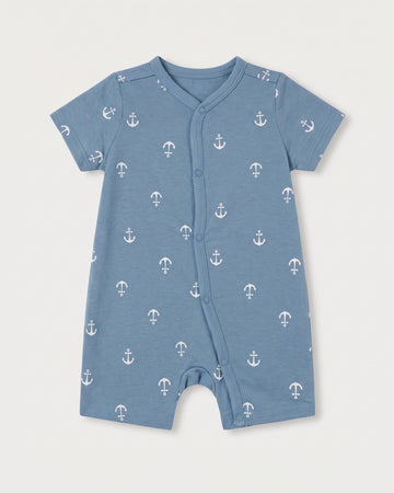 Steel blue baby jumpsuit with white nautical anchor print, short sleeves, and diagonal snap button front, flat lay on white background