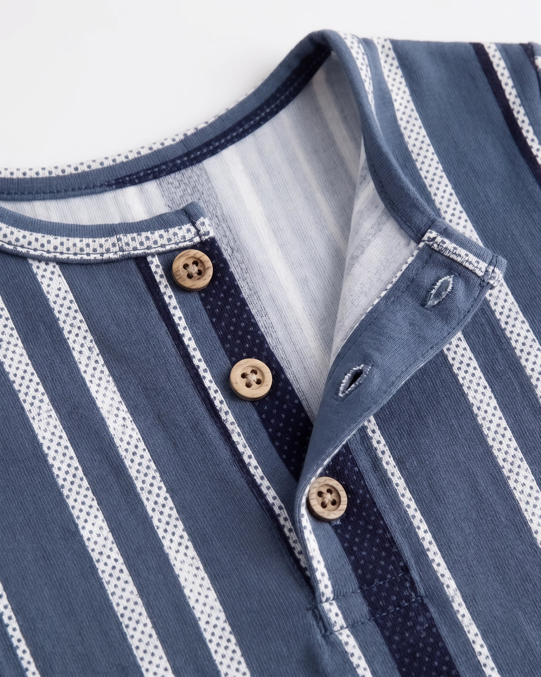 Blue striped baby romper on a wooden hanger showing button placket and leg press studs — PTex Fashion