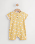 Yellow sheep print baby romper on a wooden hanger showing button placket and leg press studs — PTex Fashion