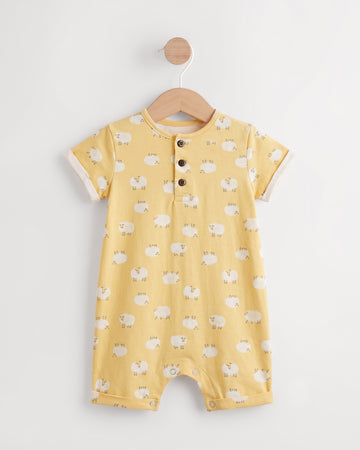 Yellow sheep print baby romper on a wooden hanger showing button placket and leg press studs — PTex Fashion