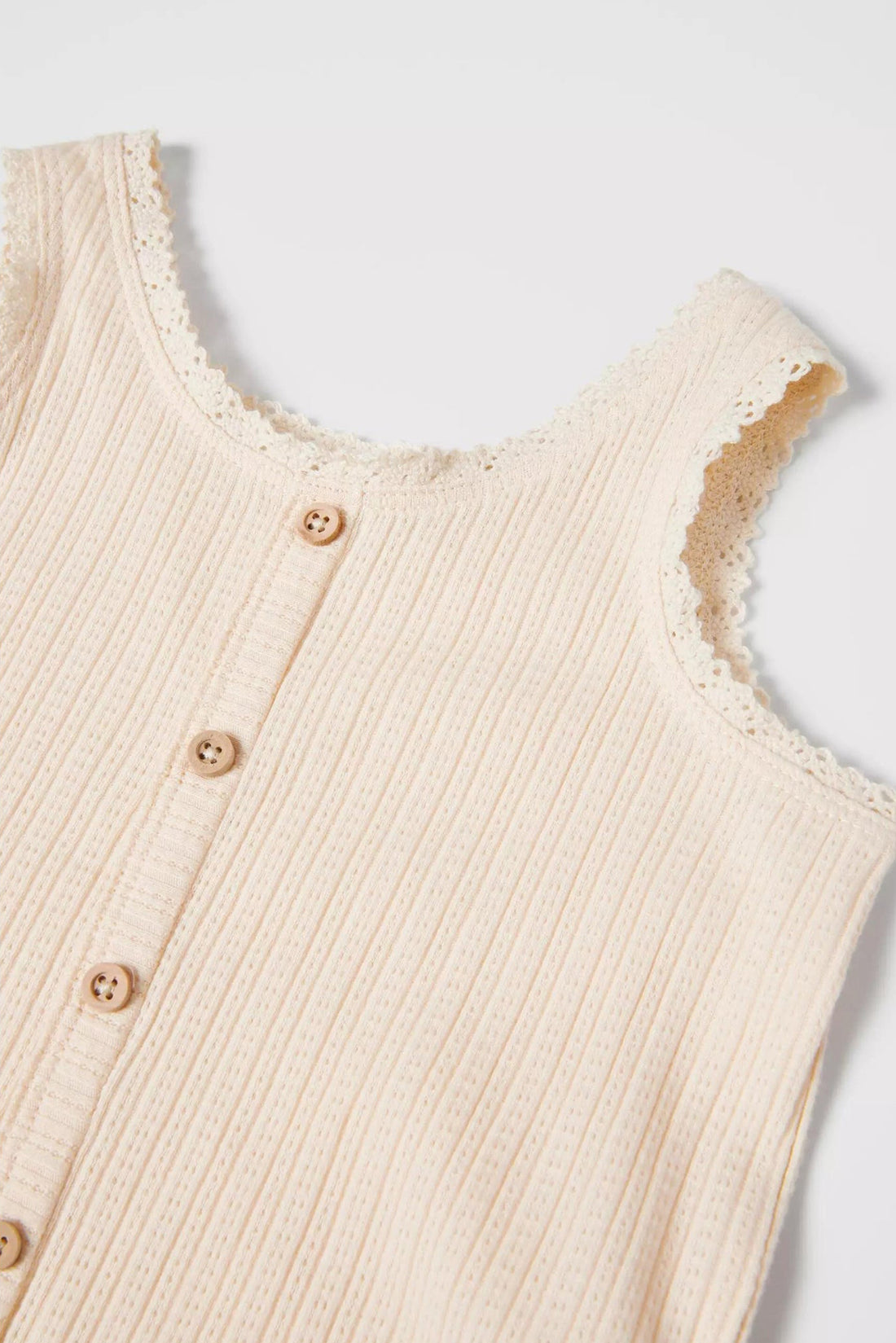 Sleeveless girls open knit top with a round neck