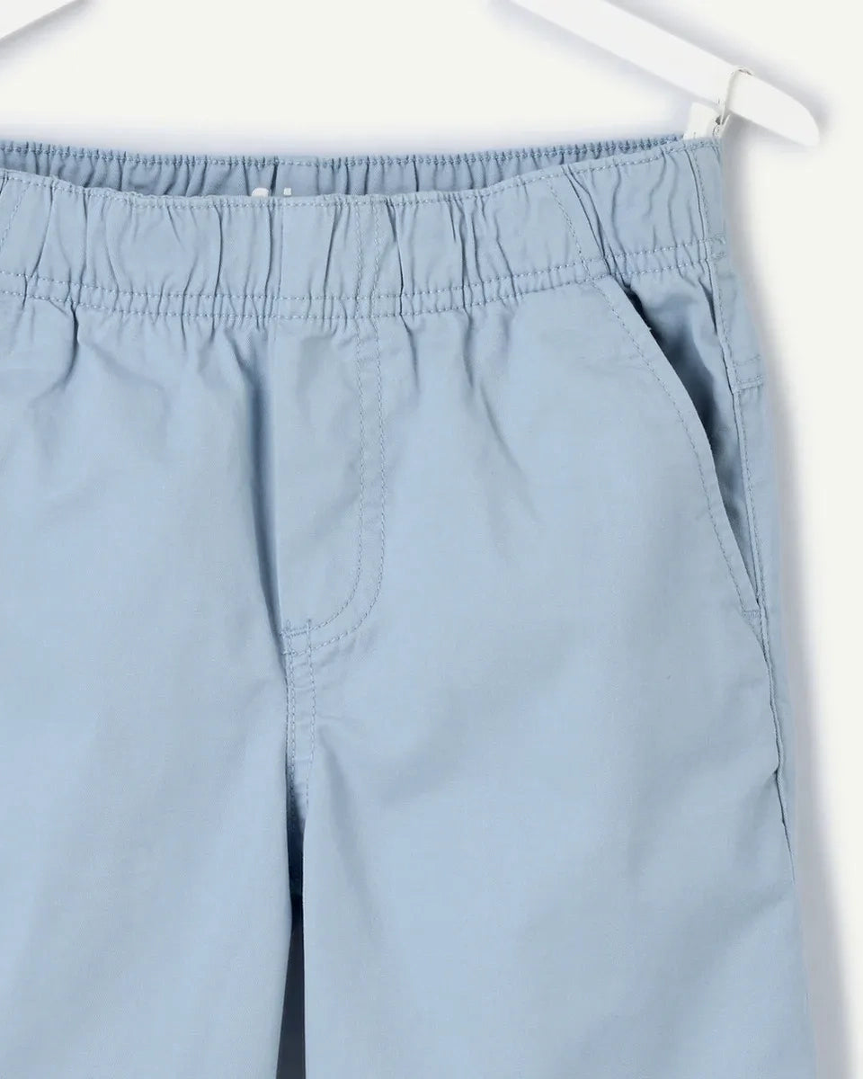 Sky blue pull-on chino shorts for boys, front view showing relaxed fit, elasticated waistband, side seam pockets, and clean tonal stitching on lightweight cotton-blend twill.